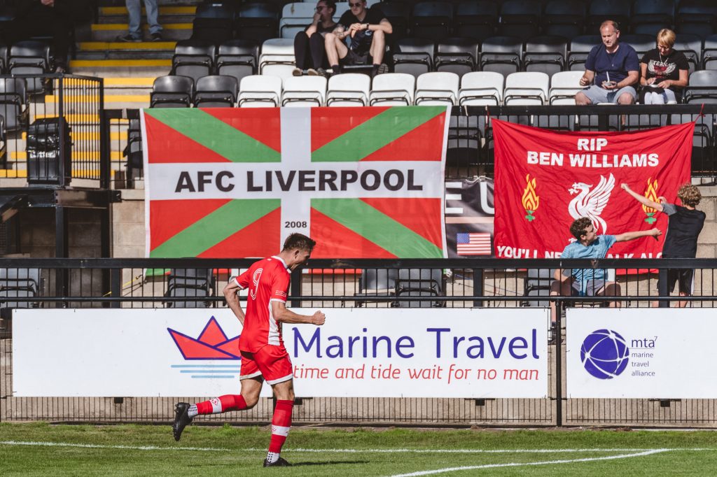 AFC Liverpool striker Dan Cockerline wheels away in celebration after scoring
